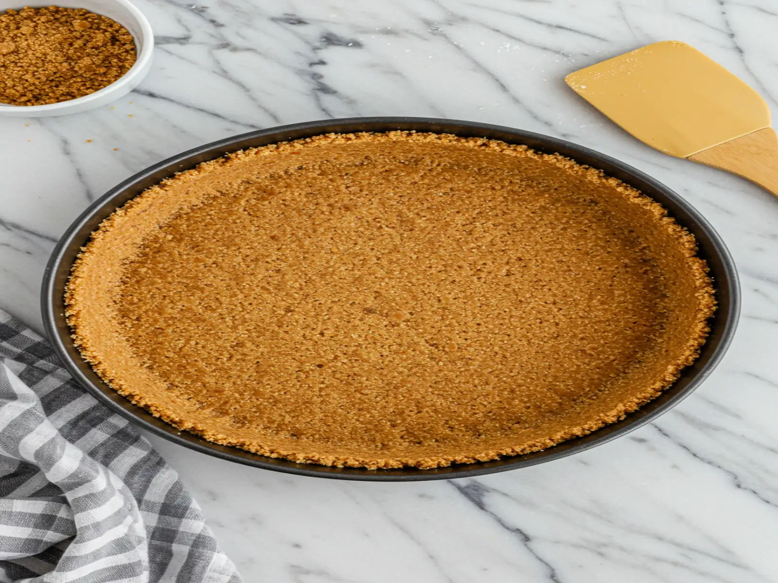 crust-prep-graham-cracker-base.webp graham cracker crust pressed into springform pan